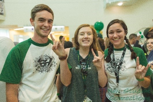 Three students holding up the bulls hand sign
