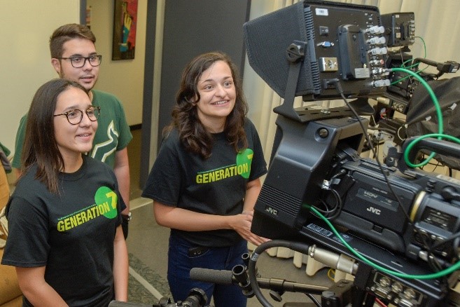Students recording a video in front of a camera and teleprompter